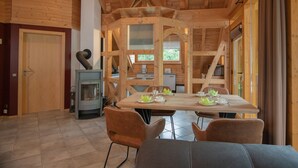 A wooden interior with a dining area, a fireplace, and a door.