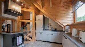A modern kitchen with wooden beams, a built-in oven, and a sink.