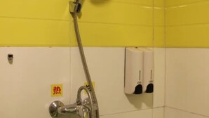 A shower area with yellow and white tiles, a chrome showerhead, and a soap dispenser on the wall. - Dong Chang'an Hotel Beijing Shuangjin (Beijing)