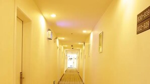 A hotel hallway with a carpeted floor and a sign displaying phone numbers. - Dong Chang'an Hotel Beijing Shuangjin (Beijing)