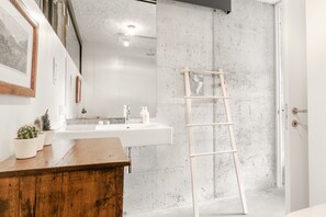 A bathroom with a wooden vanity, a white sink, and a ladder leaning against the wall. - A tranquil paradise overlooking the lake (Arco)
