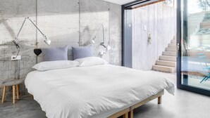 A modern bedroom with a large bed, bedside lamps, and a view of a wooden staircase. - A tranquil paradise overlooking the lake (Arco)