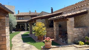 A stone building with a tiled roof, a stone pathway, and a green lawn. - CAL SERRA-Rural house (Alentorn)