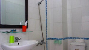 A bathroom with a white sink, a mirror, a shower, and a toilet. - Sen Vang Guest House (Nha Trang)