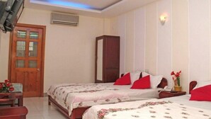 A bedroom with two beds, a wooden wardrobe, a desk with a chair, and a door. - Sen Vang Guest House (Nha Trang)
