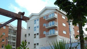 A multi-story building with balconies and a sign that reads "CENTURIC".