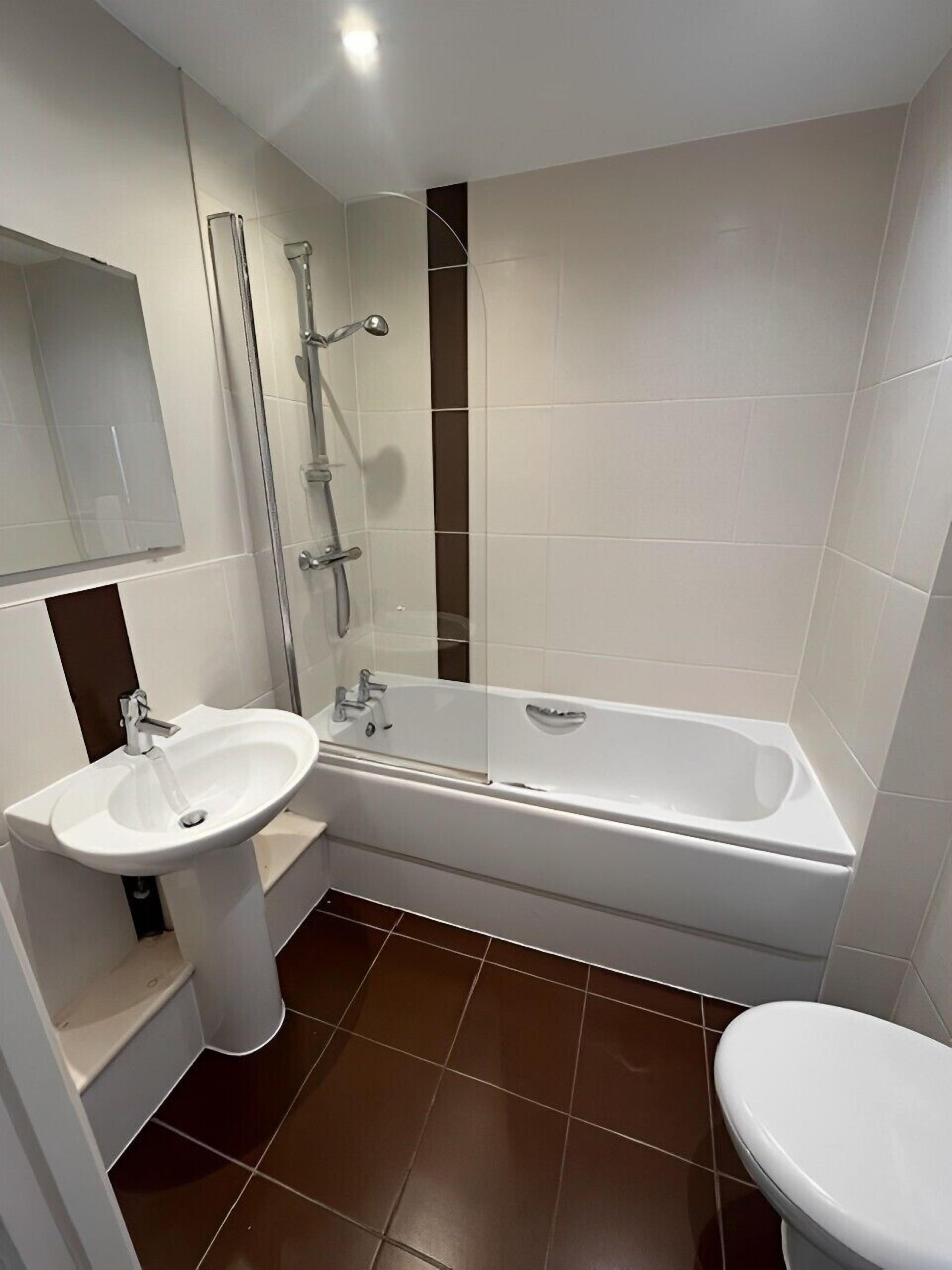 Ein modernes Badezimmer mit Waschbecken, Badewanne und Dusche.