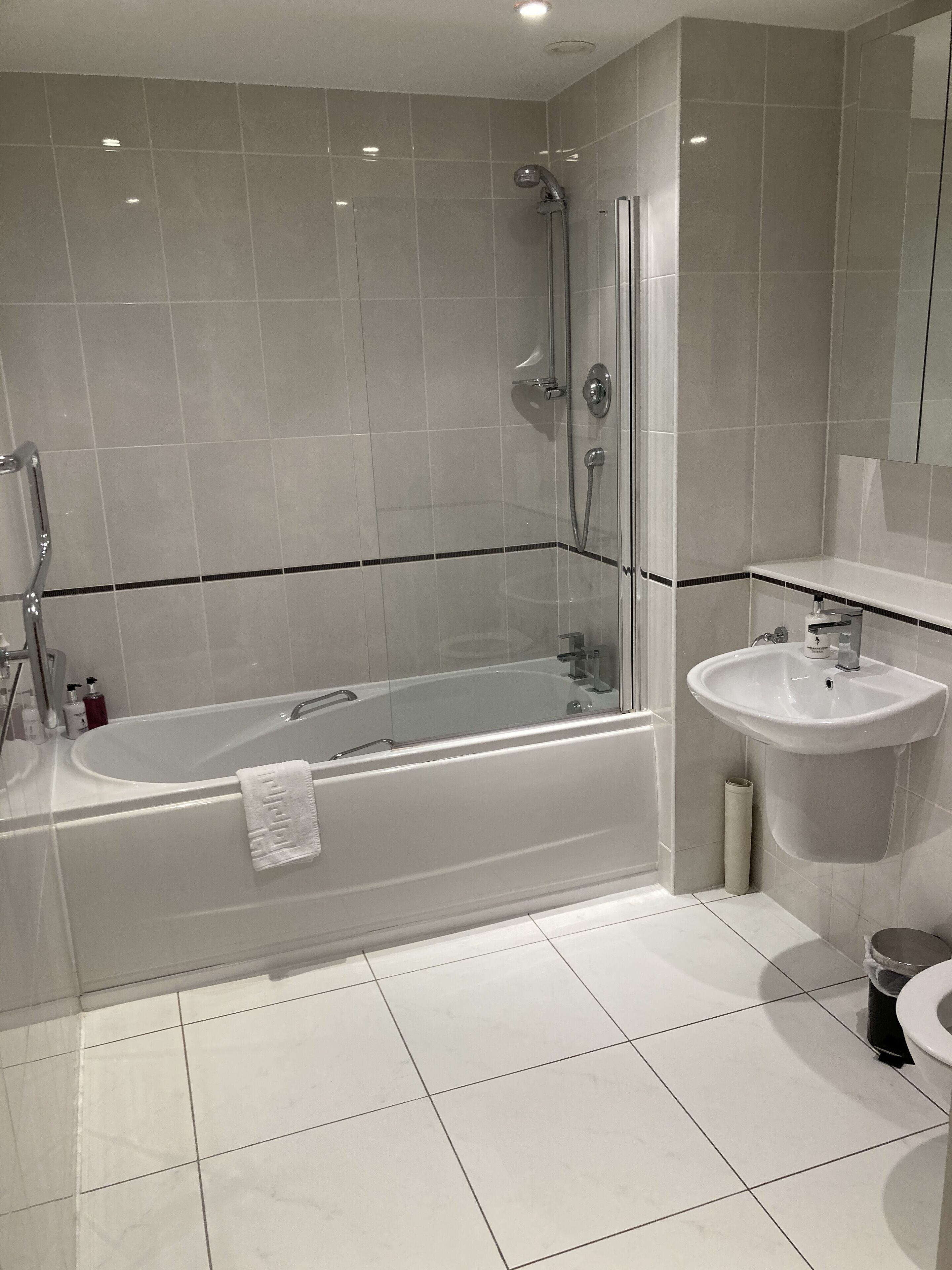 A modern bathroom with a freestanding bathtub, a glass-enclosed shower, and a pedestal sink.