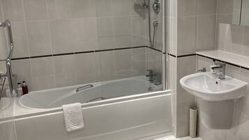 A modern bathroom with a freestanding bathtub, a glass-enclosed shower, and a pedestal sink.