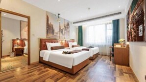A hotel room with a large bed, a desk, and a view of the city. - James Joyce Coffetel (Beijing)