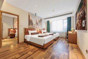 A hotel room with a large bed, a desk, a chair, a mirror, and a window with curtains. - James Joyce Coffetel (Beijing)