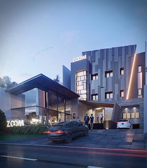 A modern building with a 'ZOOM' sign, a covered entrance, and a car parked in front.