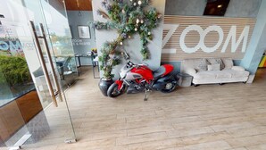 Um interior moderno com uma moto, um sofá e uma placa na parede.