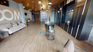 Um saguão de hotel com uma recepção, um sofá e uma mesa de centro.