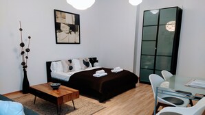 A modern bedroom with a bed, bedside table, and a glass table with chairs. - Quiet studio in Prenzlauer Berg near Mauerpark (Berlin)