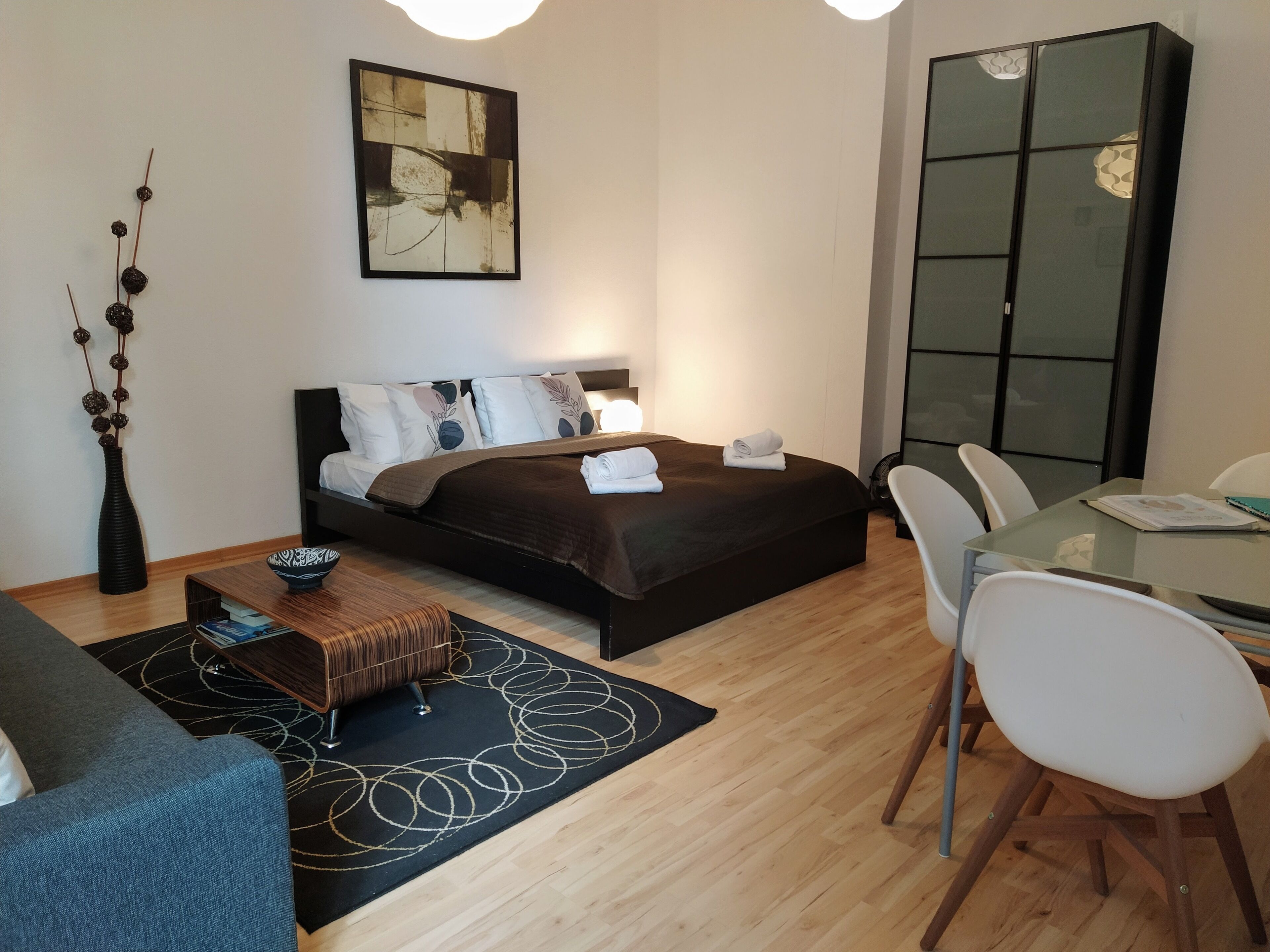 A modern bedroom with a bed, a desk, and a chair.