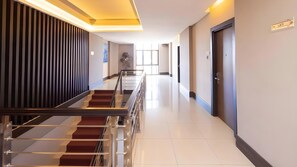 A hotel corridor with a staircase, doors, and a lift sign. - Diamond Hotel Samarinda (Samarinda)