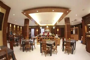 A spacious hotel dining area with multiple tables and chairs, a central buffet, and a modern ceiling design. - Diamond Hotel Samarinda (Samarinda)