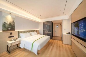 A modern hotel room with a large bed, bedside table, and a flat-screen TV. - Greentree Inn Xuzhou West District Huohua Shell Ho (Xuzhou)