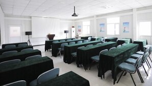 A conference room with multiple tables and chairs, a projector, and a screen. - Greentree Inn Baoding Sanfeng Road Agricultural Un (Baoding)