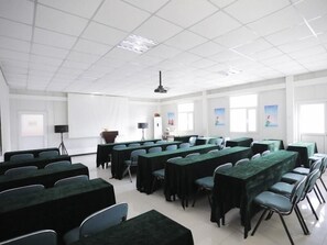 A conference room with multiple tables and chairs, a projector, and a screen. - Greentree Inn Baoding Sanfeng Road Agricultural Un (Baoding)