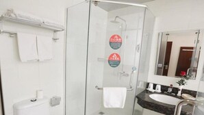 A modern bathroom with a glass-enclosed shower, a white toilet, a sink with a marble countertop, and a mirror above the sink. - Greentree Inn Baoding Sanfeng Road Agricultural Un (Baoding)