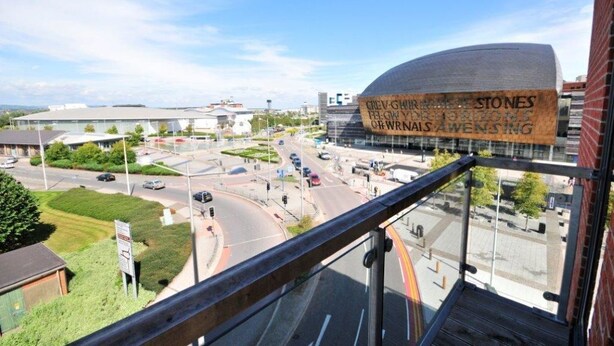 A view from a high vantage point overlooking a city intersection with a distinctive building featuring a large, curved facade. - Quayside by Urban Space (Cardiff)