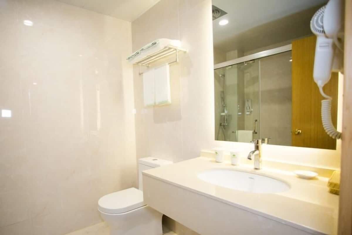 A modern bathroom with a toilet, sink, and mirror.