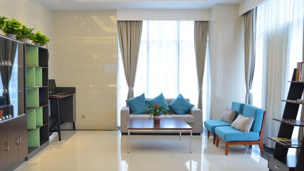A modern living room with a sofa, coffee table, and bookshelf. - Greentree Inn Suzhou Changshu Huanghe Road Linli C (Suzhou)