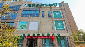 A hotel building with multiple banners and flags, including a prominent Green Tree Inn sign. - Greentree Inn Suzhou Changshu Huanghe Road Linli C (Suzhou)