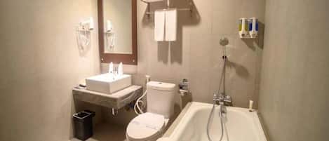 A bathroom with a toilet, sink, mirror, towel rack, and bathtub.