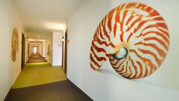 Un pasillo con una gran obra de arte espiral en la pared.