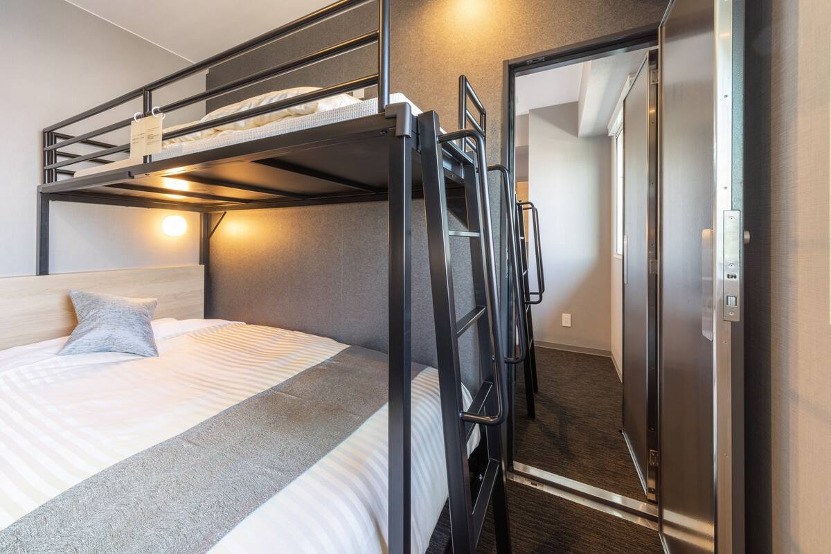 Una cama individual con cabecera, una mesita de noche y una lámpara.