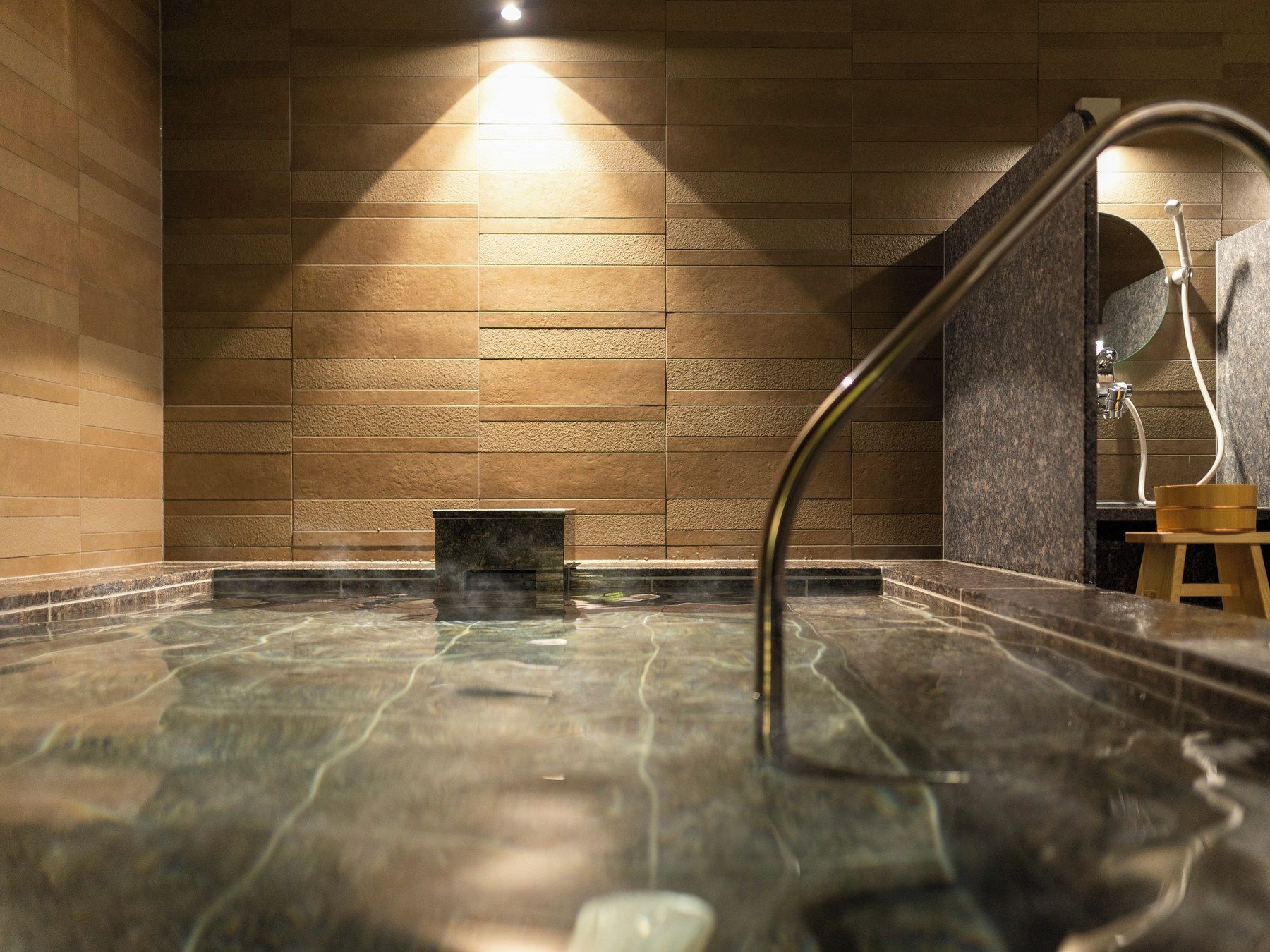 Un jacuzzi con piso de baldosas y una pared con textura.