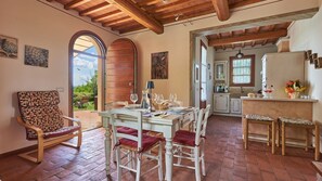 A rustic dining area with a brick floor, wooden beams, and a table set for four. - Casetta Di Petriolo, Cerreto Guidi, Florence and Chianti (Cerreto Guidi)