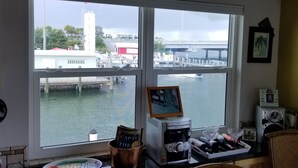A kitchen with a view of a bridge and water, featuring wooden cabinets, a coffee maker, and a picture frame on the counter. - Fisherman's Paradise (Marathon)