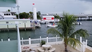 A marina with boats docked, a white fence, and a palm tree. - Fisherman's Paradise (Marathon)