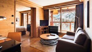 Un intérieur chaleureux en bois, avec un canapé, une table basse ronde et un téléviseur.