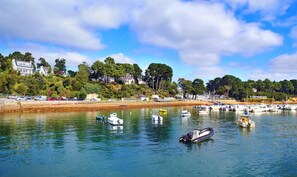 A marina with various boats, a sandy beach, and houses in the background. - Unusual night on the peninsula of Rhuys (Sarzeau)