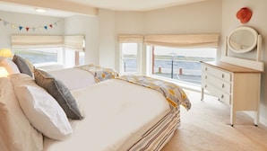 A bedroom with two beds, a dresser, a mirror, and a view of the outside. - Host & Stay | Sunset View (Whitby)