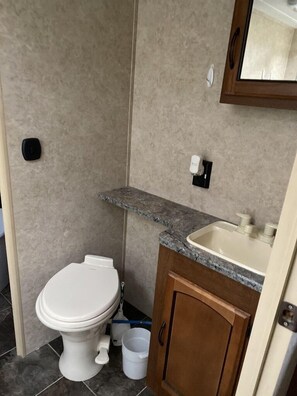Ein Badezimmer mit Toilette, Waschbecken und Spiegel.