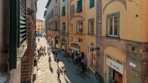 A narrow street lined with buildings, some with shops and signage, and bicycles parked along the sides.