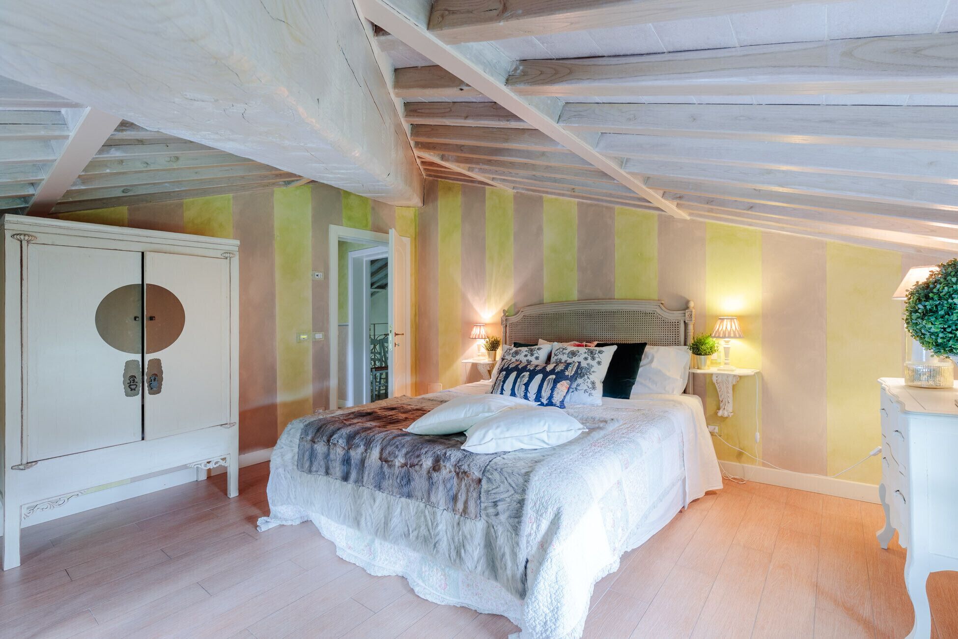 Ein Schlafzimmer mit Bett, Nachttisch, Lampe und Kleiderschrank.
