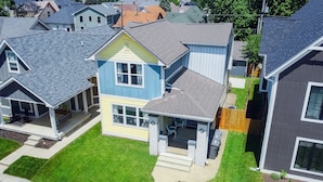 A residential area with multiple houses, including a two-story house with a front porch and a garage.