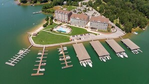 Vista aérea de un hotel con un edificio grande, una piscina y varios muelles para barcos.