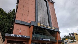 A hotel with a reception and restaurant on the ground floor, featuring a modern design with a prominent glass facade. - Golden Metro Hotel (Bengaluru)