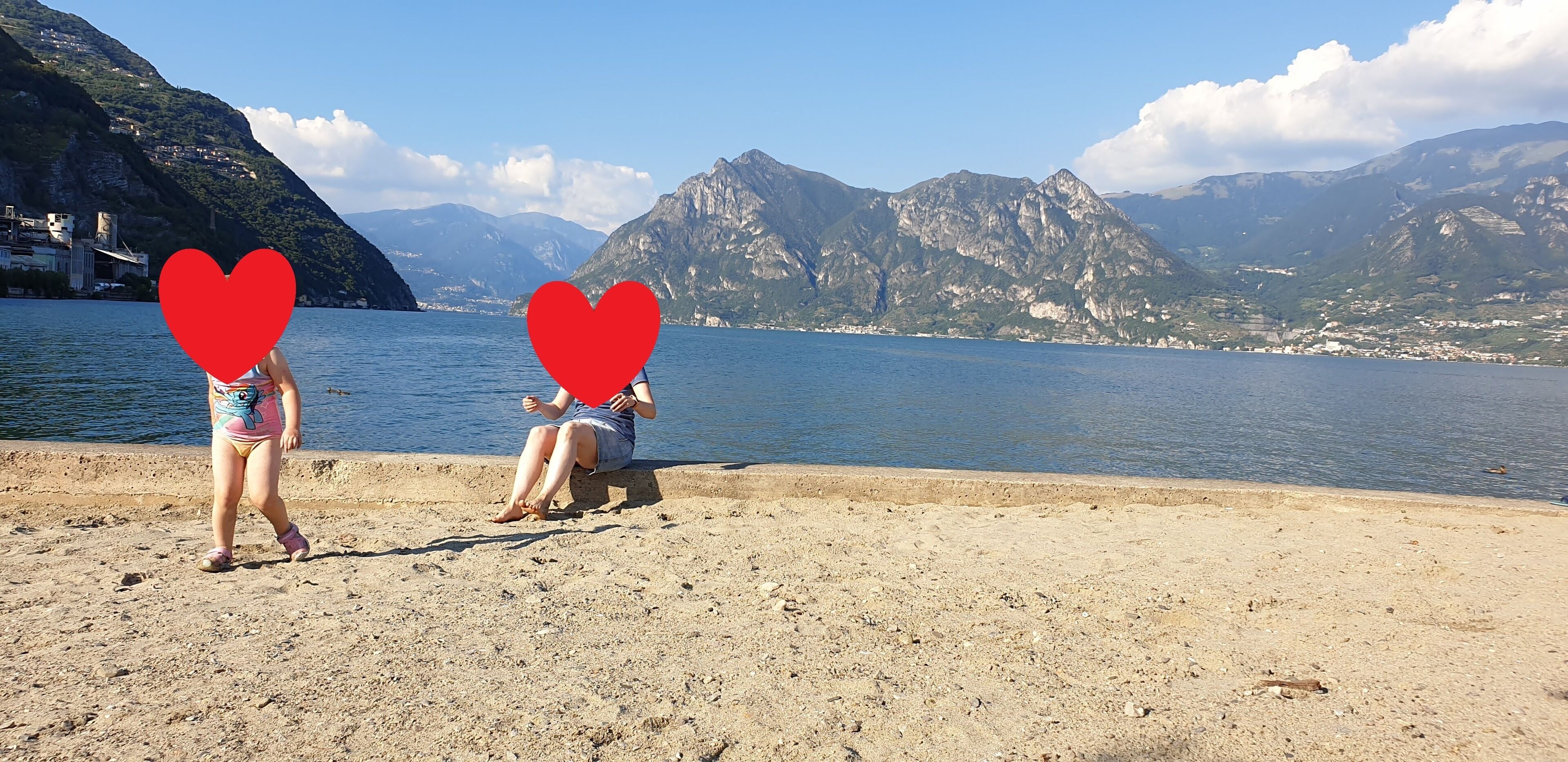 Spiaggia con montagne sullo sfondo e un corpo d'acqua.