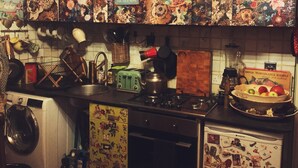 Una cuina amb decoració antiga, incloent un relleu de fons amb un disseny floral i una torradora d'estil vintage.