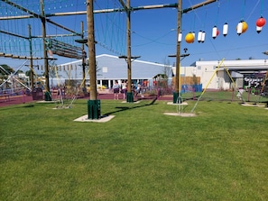 Ein Spielplatz im Freien mit Klettergerüsten und Schaukeln.