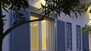 A building with blue shutters, a large glass door, and a potted plant on the ground. - House with pool (Pompei)